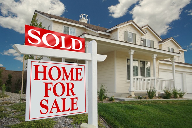 Image of a for sale sign in front of a home.