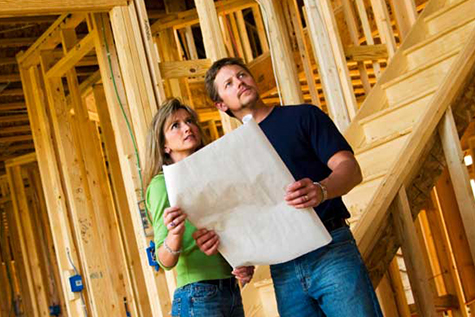 Image of couple looking plans for their home build.