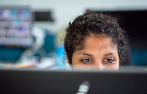 Image of woman staring at a computer screen.