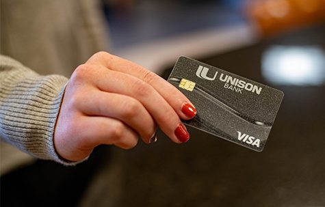 A customer holds a Unison Bank debit card.
