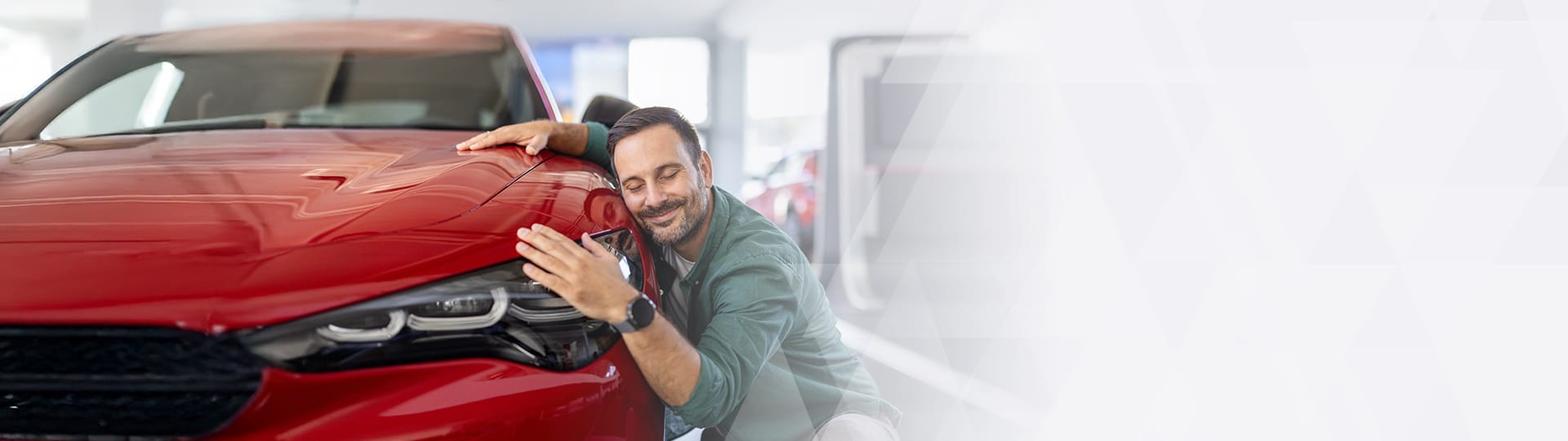 Homepage banner image of a man hugging his red vehicle.